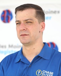 a man in a blue shirt standing in front of a banner